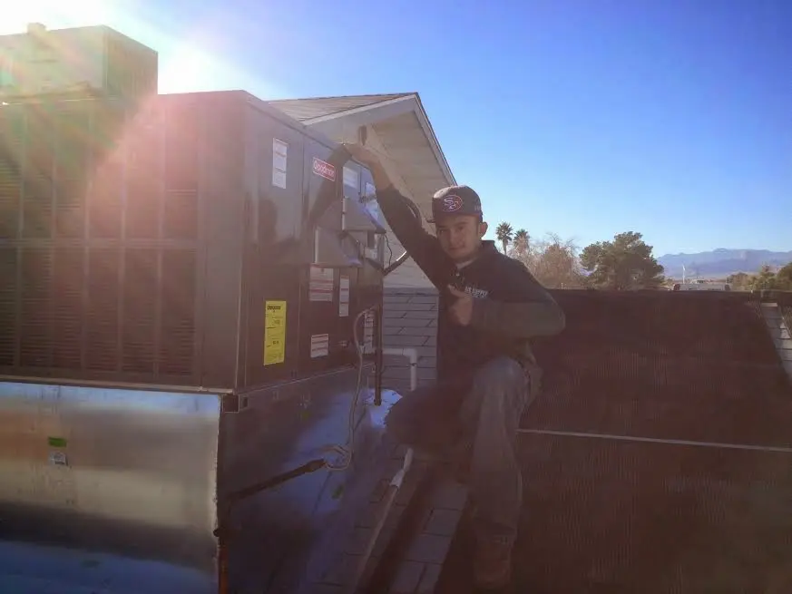 HVAC technician performing HVAC Inspection on a rooftop unit in Plymouth
